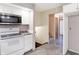 Kitchen with white appliances and cabinets, view of stairway at 13832 W Old Nashville Rd, Columbus, IN 47201