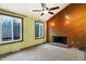 Spacious living room featuring a fireplace, wood-paneled accent wall, and ample natural light at 13832 W Old Nashville Rd, Columbus, IN 47201