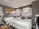 Basement bedroom with twin beds and stone accent wall at 501 Fletcher Ave # Apt A, Indianapolis, IN 46203