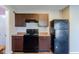 Kitchen with black appliances, brown cabinets, and wood-look flooring at 10938 Delphi Dr, Camby, IN 46113
