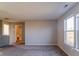 Living room with neutral walls, carpet, and adjacent bathroom at 10938 Delphi Dr, Camby, IN 46113