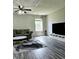 Living room featuring gray sofas, a large TV, and hardwood floors at 5236 Bluff View Dr, Indianapolis, IN 46217