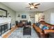 Living room with fireplace, two leather sofas, and ceiling fan at 7650 Prairie Fire Ct, Brownsburg, IN 46112