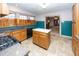 Kitchen with wood cabinets, island, and teal backsplash at 1330 N Bosart Ave, Indianapolis, IN 46201