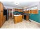 Kitchen with wood cabinets, island, and teal backsplash at 1330 N Bosart Ave, Indianapolis, IN 46201