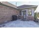 Brick patio with grill, access door, and mature landscaping at 1504 Wildwood Ct, Plainfield, IN 46168