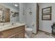 Clean bathroom with wood vanity, toilet, and decorative wall art at 1504 Wildwood Ct, Plainfield, IN 46168