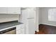 White kitchen cabinets, stainless steel dishwasher, and refrigerator at 1709 Queensbridge Dr, Indianapolis, IN 46219