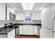 Modern kitchen with white cabinets, stainless steel appliances, and dark countertops at 1709 Queensbridge Dr, Indianapolis, IN 46219