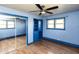 Blue bedroom with hardwood floors, ceiling fan and built-in shelving at 619 E Buchanan St, Plainfield, IN 46168