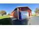 Red metal garage with white door and vintage pump at 7919 W County Road 100 South, Coatesville, IN 46121