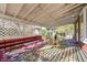 Covered back porch with wooden seating and lattice details at 80 S Mickley Ave, Indianapolis, IN 46241