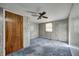Bright bedroom featuring wood-paneled walls, ceiling fan, and carpeting at 80 S Mickley Ave, Indianapolis, IN 46241