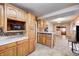 Kitchen with wood cabinets, island, and view into dining area at 80 S Mickley Ave, Indianapolis, IN 46241