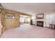 Living room with pink carpet, wood paneling, and a fireplace at 80 S Mickley Ave, Indianapolis, IN 46241