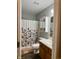 Bathroom with double sinks, floral shower curtain, and wood cabinet at 10048 New Dawn Pl, Avon, IN 46123