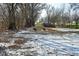 Partially snow covered backyard with leaf covered ground at 11365 W State Road 142, Martinsville, IN 46151