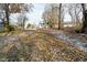Partially snow covered backyard with leaf covered ground at 11365 W State Road 142, Martinsville, IN 46151
