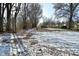 Partially snow covered backyard with leaf covered ground at 11365 W State Road 142, Martinsville, IN 46151