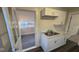 Kitchen with white cabinets, a sunroom view, and a double sink at 4745 W Legrande Ave, Indianapolis, IN 46241