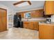 Kitchen with oak cabinets, black appliances, and tile floor at 5059 Countess Dr, Columbus, IN 47203