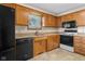 Kitchen with oak cabinets, black appliances and tile floors at 5059 Countess Dr, Columbus, IN 47203