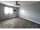 Grey bedroom with ceiling fan, carpet, and window with sheer curtains at 1425 Lawrence Way, Anderson, IN 46013