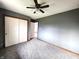 Bedroom featuring grey walls, carpet, ceiling fan and double closet at 1425 Lawrence Way, Anderson, IN 46013