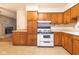 Retro kitchen with wood cabinets, white stove, and tile floor at 217 N State Road 75, Danville, IN 46122