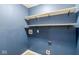 Laundry room with blue walls and built-in shelving at 2990 W Broderie Ln, Monrovia, IN 46157