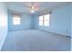 Blue bedroom with plush carpet, two windows and a ceiling fan at 4770 Winterberry Pl, Columbus, IN 47201