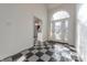 Elegant entryway featuring a checkerboard floor, a staircase, and an arched glass door at 4770 Winterberry Pl, Columbus, IN 47201