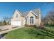 Beige two-story house with three-car garage and landscaped yard at 4770 Winterberry Pl, Columbus, IN 47201