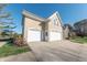 Three-car garage with white doors and concrete driveway at 4770 Winterberry Pl, Columbus, IN 47201