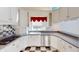 White kitchen with stainless steel appliances and a charming red valance at 4770 Winterberry Pl, Columbus, IN 47201