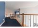 Spacious loft area with wood railings and blue carpet at 4770 Winterberry Pl, Columbus, IN 47201