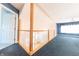 Open loft hallway with wood railing and blue carpeting at 4770 Winterberry Pl, Columbus, IN 47201