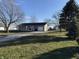 Gray house with attached garage and deck, situated on a spacious lawn at 6095 W 1900 N, Elwood, IN 46036