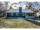 Rear view of blue house with screened porch, snowy yard, and chain link fence at 12128 Rossi Dr, Indianapolis, IN 46236