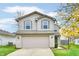 Two-story house with beige siding, brick accents, and a two-car garage at 15230 Fawn Meadow Dr, Noblesville, IN 46060