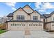 Modern two-story home with a beige and black exterior, attached two-car garages, and landscaping at 17410 Ebling Trl, Westfield, IN 46062