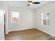 Well-lit bedroom with hardwood floors, ceiling fan and two windows at 2202 Bellefontaine St, Indianapolis, IN 46205