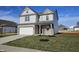 Two-story home with a front-facing garage, landscaped yard, and a small tree at 6196 Granby Dr, Whitestown, IN 46075