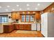 Oak kitchen with ample counter space, tile floors, and a window overlooking the backyard at 8855 Jules Ln, Indianapolis, IN 46278