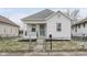 Newly renovated white bungalow home with a teal door and small front yard at 1506 E Bradbury Ave, Indianapolis, IN 46203