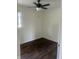 Well-lit bedroom with ceiling fan and dark brown laminate flooring at 1613 Section St, Plainfield, IN 46168