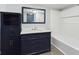 Modern bathroom with dark blue vanity, marble countertop, and a large mirror at 1814 Fairview St, Anderson, IN 46016