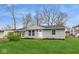 Gray exterior house with a green lawn and mature trees at 1822 E 6Th St, Anderson, IN 46012