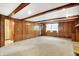 Spacious living room featuring wood paneling, beamed ceilings, and a fireplace at 2025 Hamilton Ln, Carmel, IN 46032