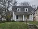 White two-story house with brown roof, steps, and small lawn at 2702 Boulevard Pl, Indianapolis, IN 46208